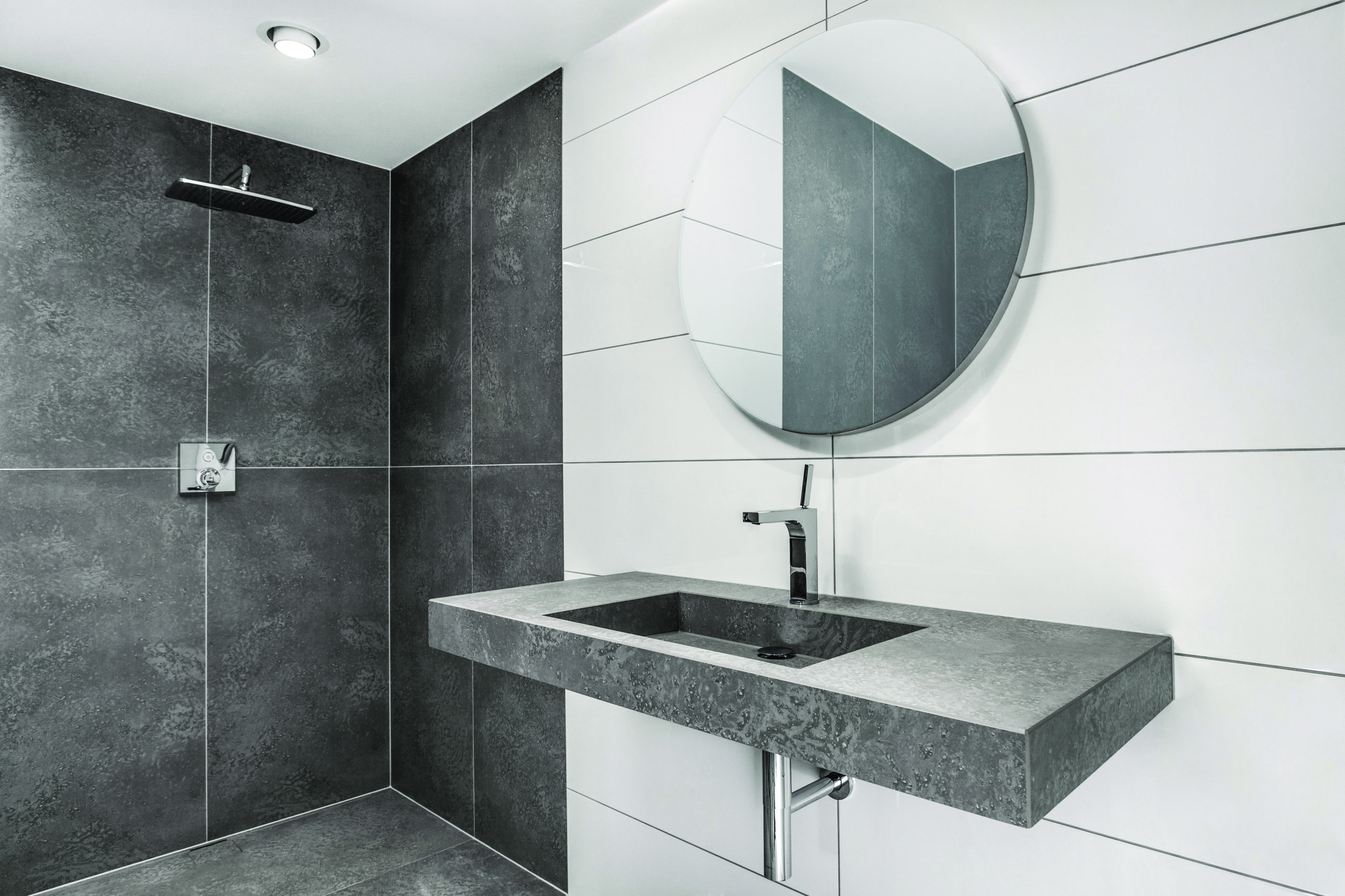 Schwarz Weiß Foto eines Badezimmers mit Dusche, Waschbecken und Spiegel